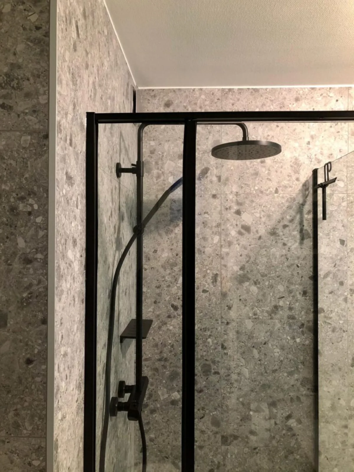 Strakke douche met terrazzo tegels — badkamerrenovatie in West-Vlaanderen