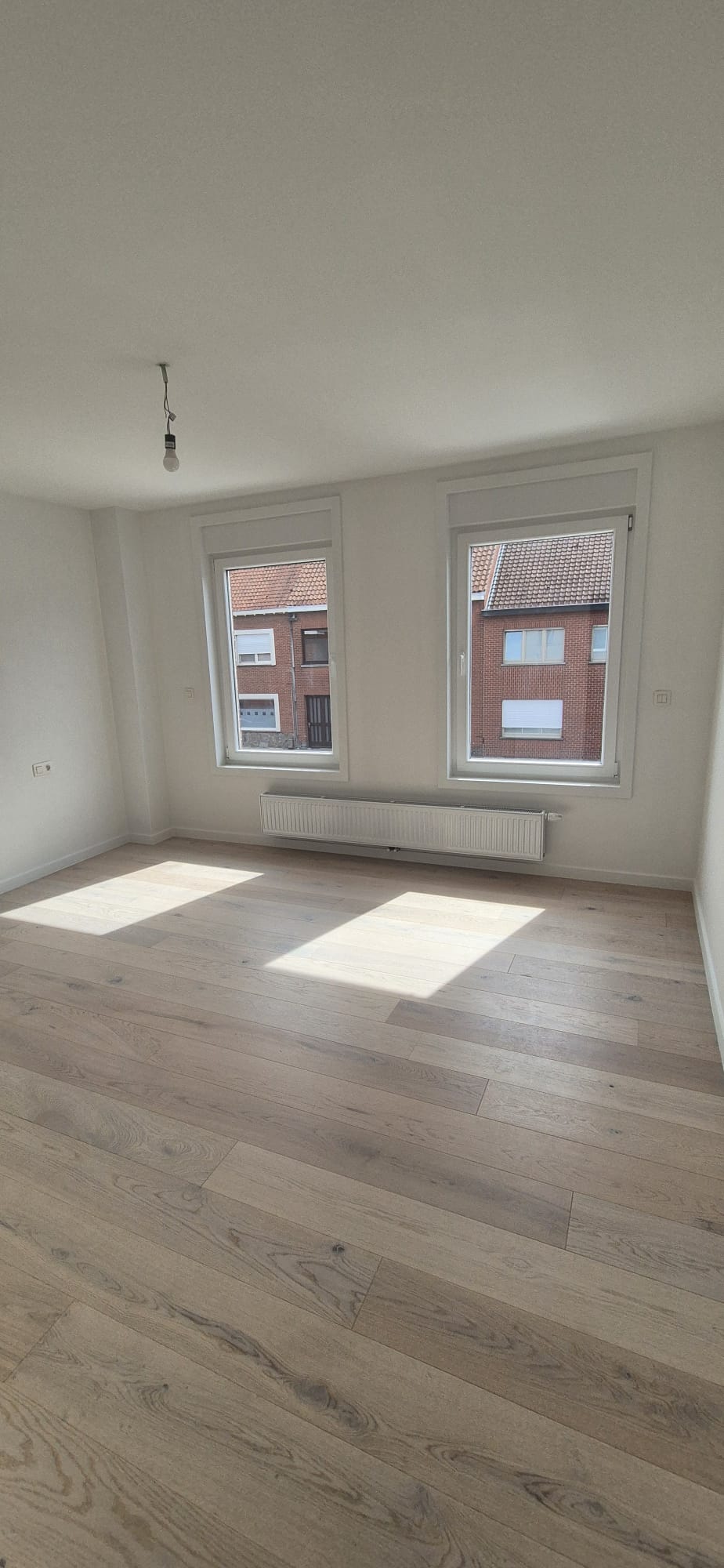 Gerenoveerde slaapkamer met massieve houten parketvloer en nieuwe radiator — Artur Niko in Ieper